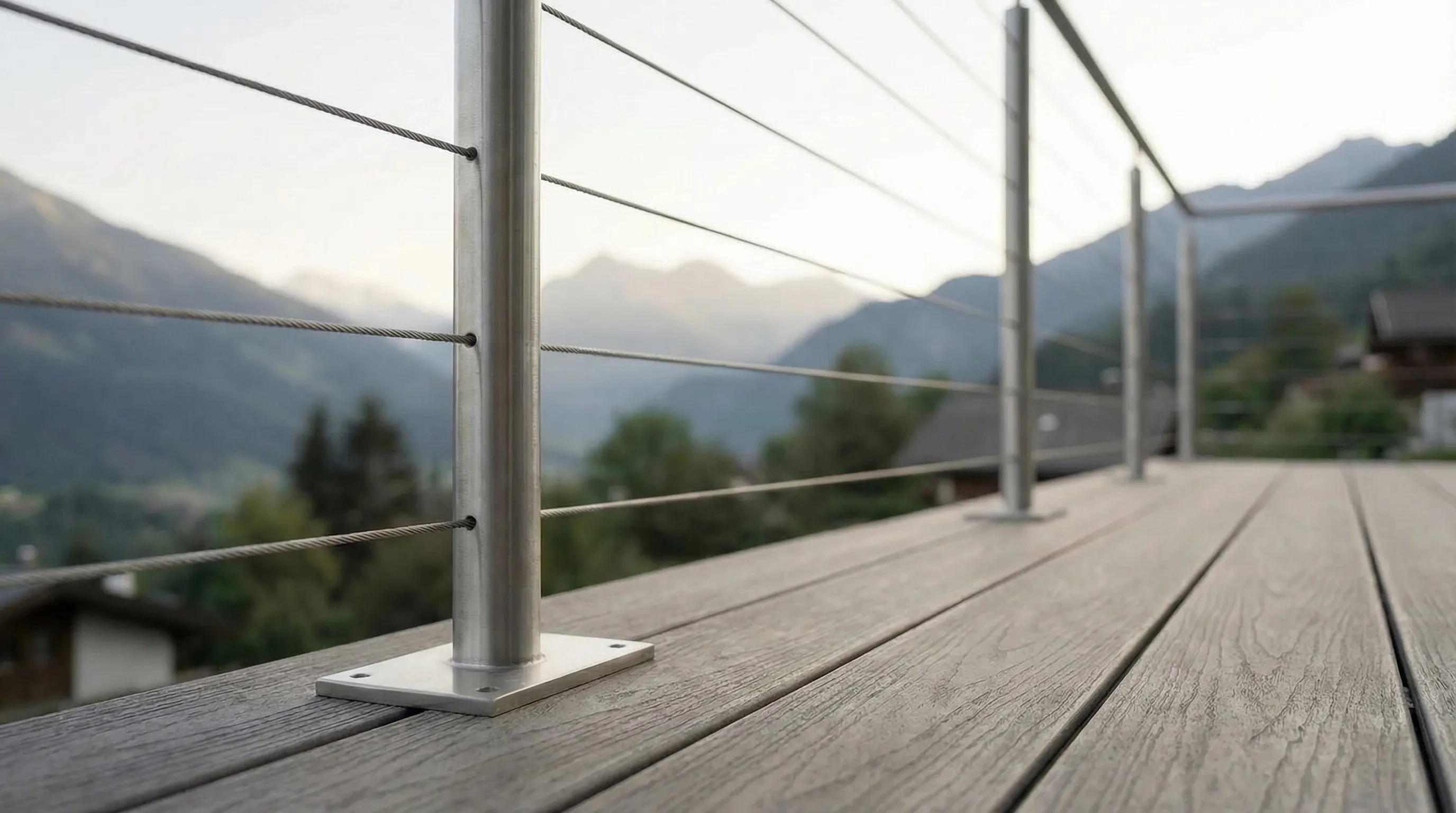 Detail garde-corps inox cables tendus sur terrasse bois en montagne